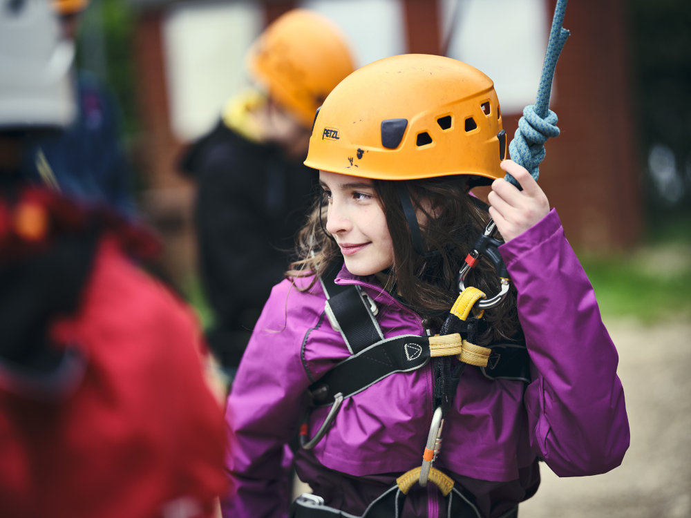 Girl in helmet attached to rope